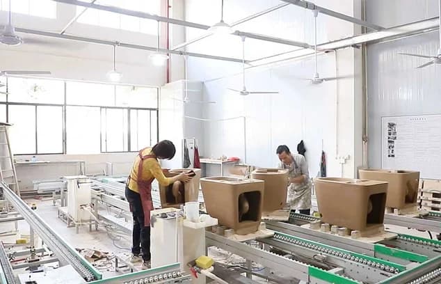 工人在修整智能马桶陶瓷坯体边缘。