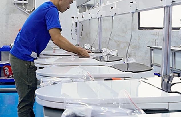 技师在产线上组装智能马桶部件。